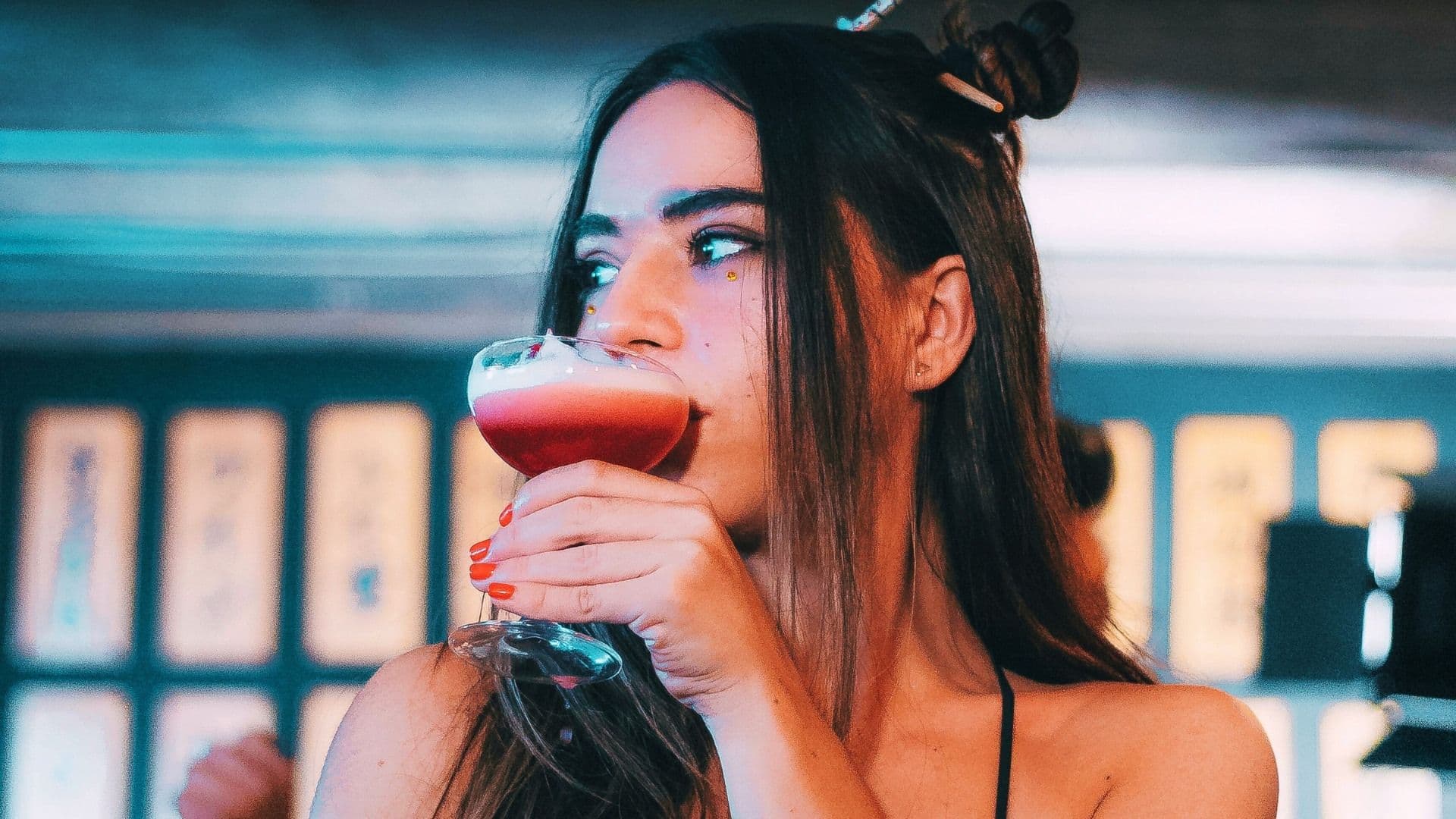 a woman drinks a cocktail as sales decline in the sector